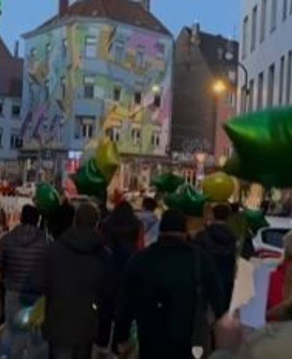 Fans ziehen mit grünen Luftballons durch Köln und feiern die Kölner Gaststätte Oma Kleinmann mit einer besonderen Aktion zum 20. Geburtstag.