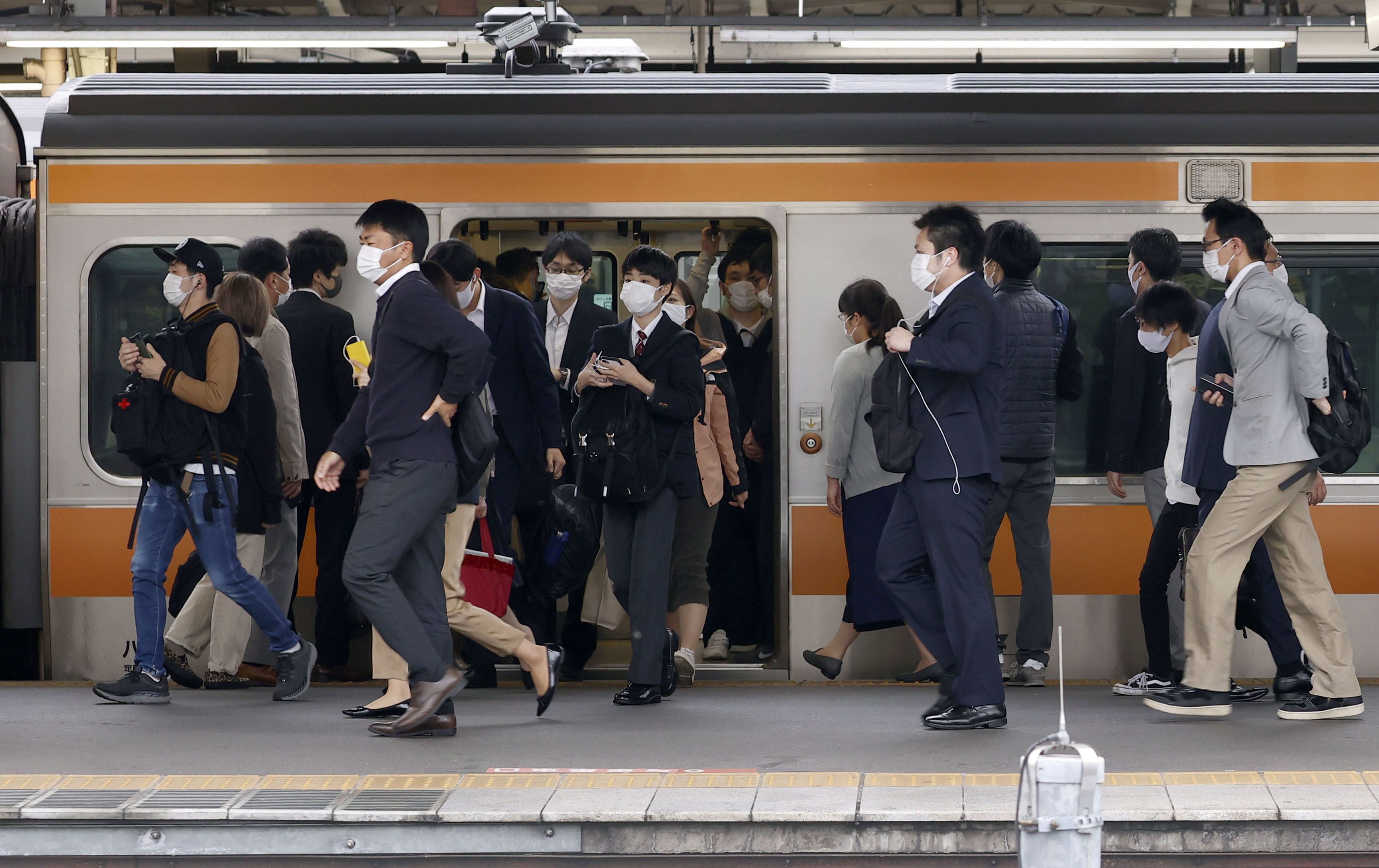 Symbolfoto. Pendler und Pendlerinnen in Tokio nach der Ferienzeit der Goldenen Woche.