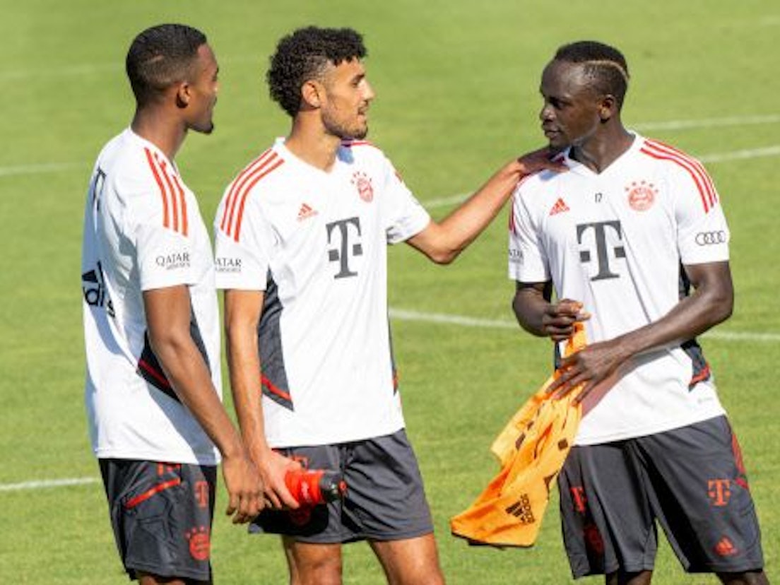 Ryan Gravenberch, Nouassir Mazraoui und Sadio Mané unterhalten sich auf dem Trainingsplatz des FC Bayern.