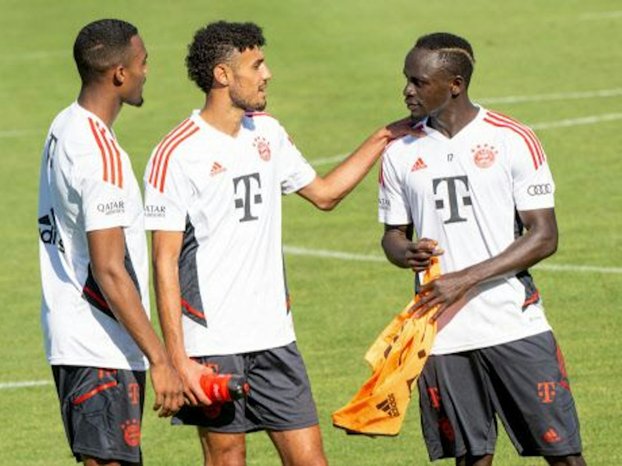 Ryan Gravenberch, Nouassir Mazraoui und Sadio Mané unterhalten sich auf dem Trainingsplatz des FC Bayern.