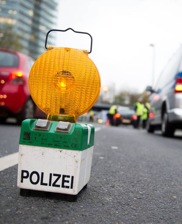 Polizeibeamte kontrollieren in Düsseldorf Fahrzeuge.