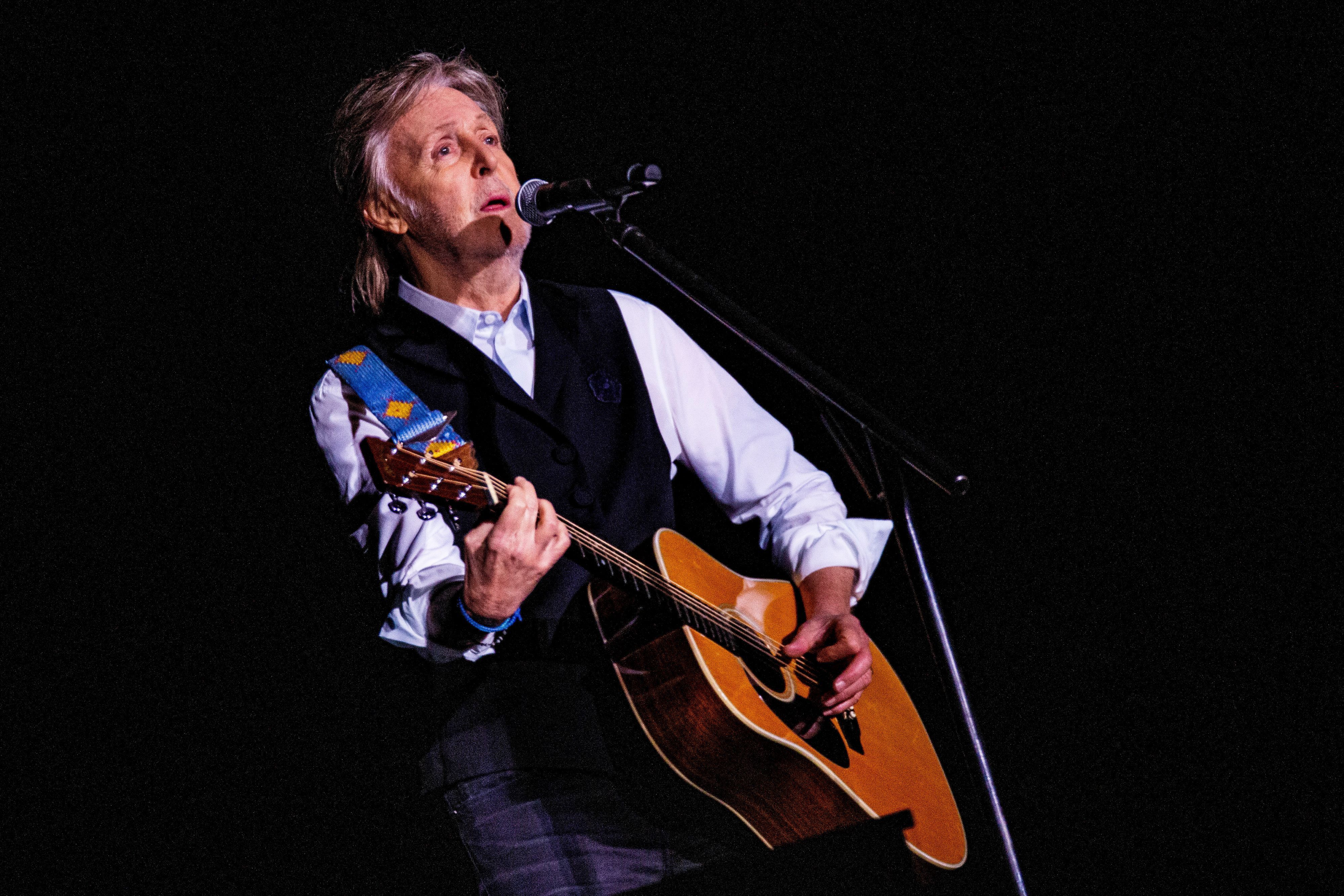 Paul McCartney spielt Gitarre.