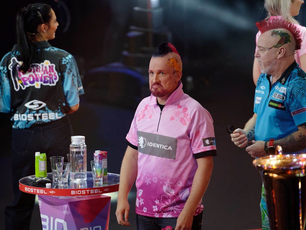 Die Moderatoren Amira und Oliver Pocher und der Profispieler Peter Wright und (l-r) stehen bei der ProSieben Promi-Darts-WM 2023 auf der Bühne.