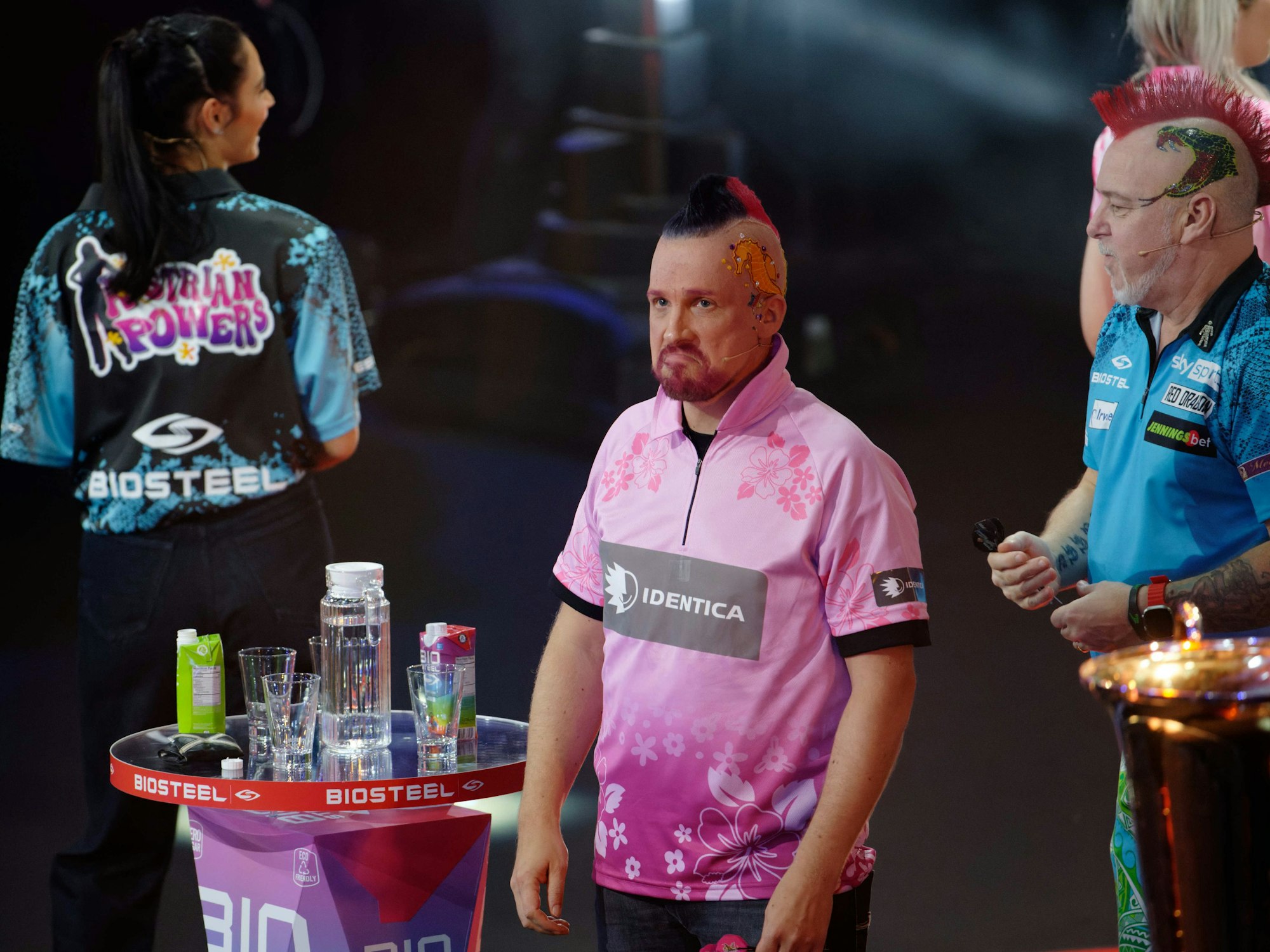 Die Moderatoren Amira und Oliver Pocher und der Profispieler Peter Wright und (l-r) stehen bei der ProSieben Promi-Darts-WM 2023 auf der Bühne.