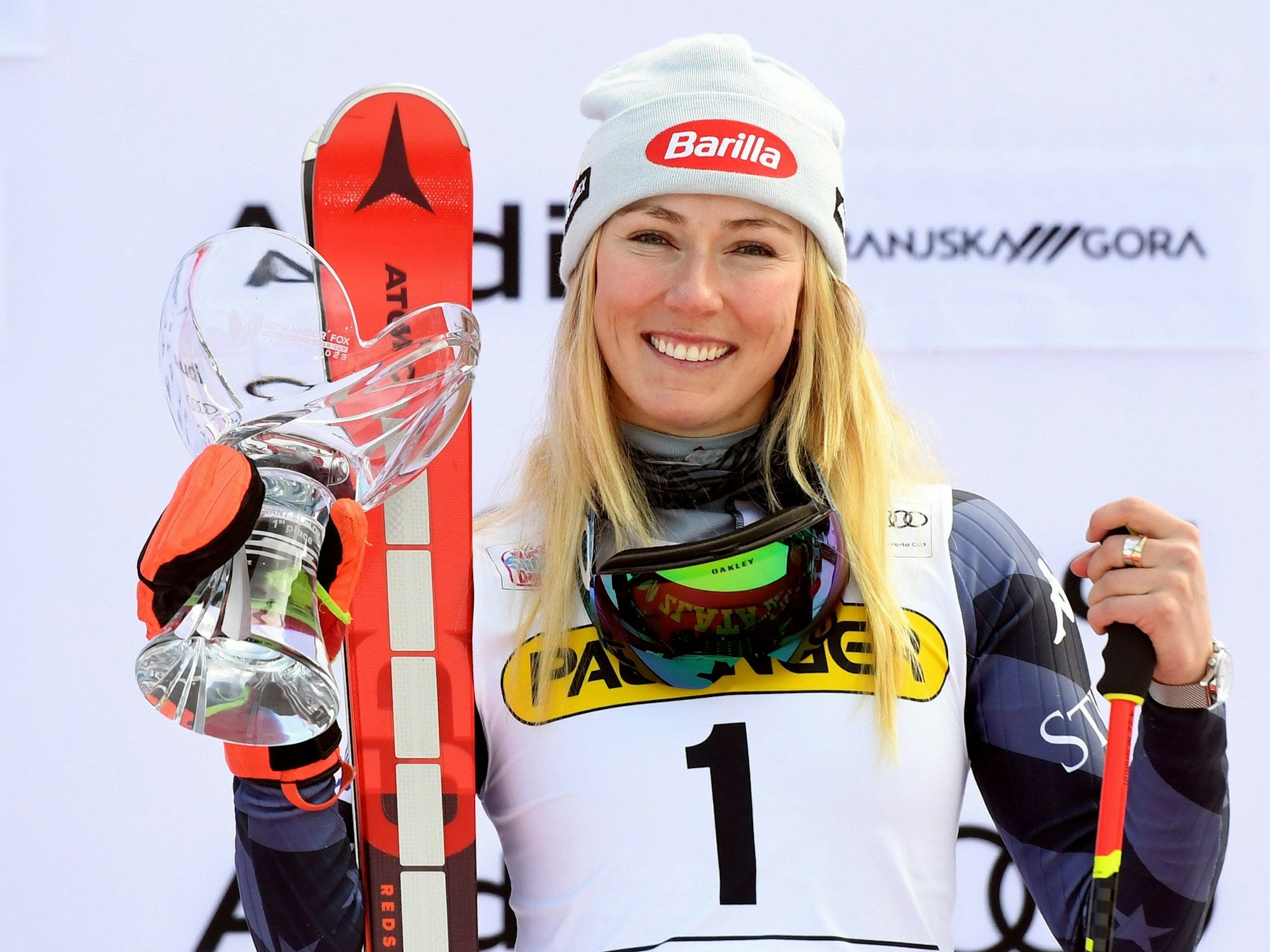 Mikaela Shiffrin lächelt nach ihrem 82. Weltcupsieg auf dem Podest in die Kamera.