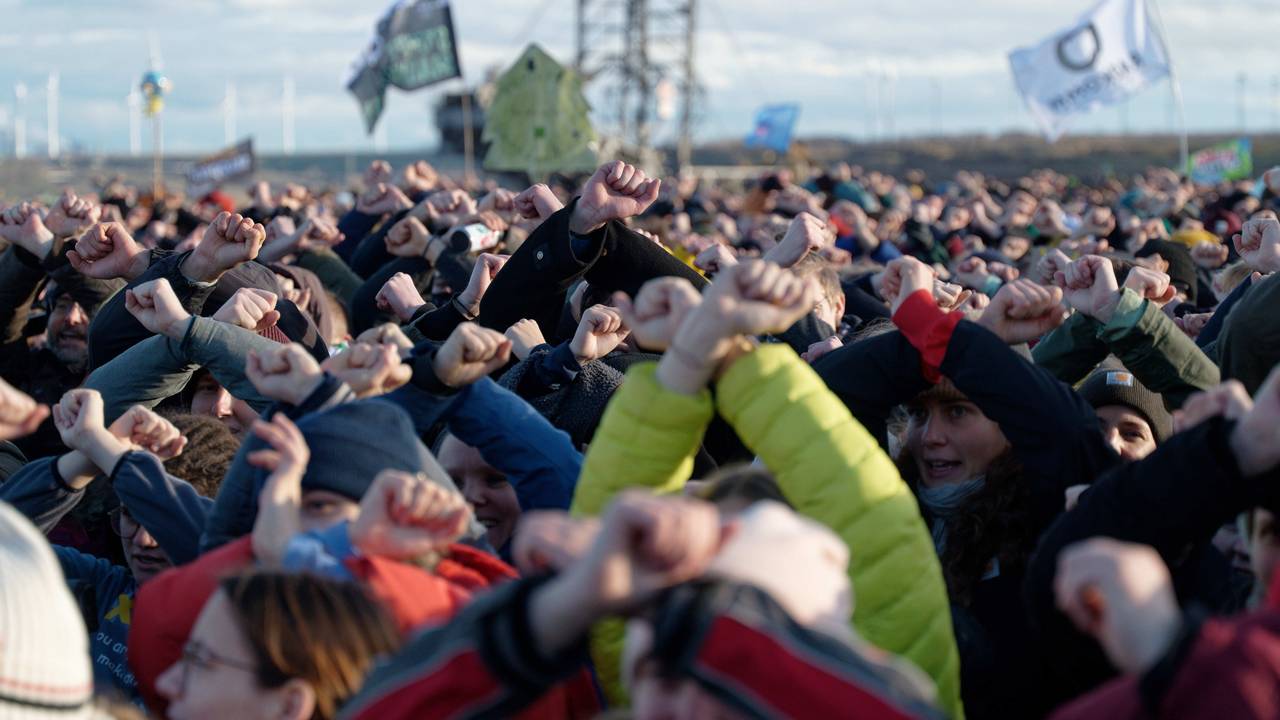Teilnehmer einer Kundgebung am Rand des Tagebaus in der Nähe von Lützerath kreuzen als zeichen des Widerstandes ihre Arme. Lützerath soll zur Erweiterung des Braunkohletagebaus Garzweiler II abgebaggert werden. +++ dpa-Bildfunk +++