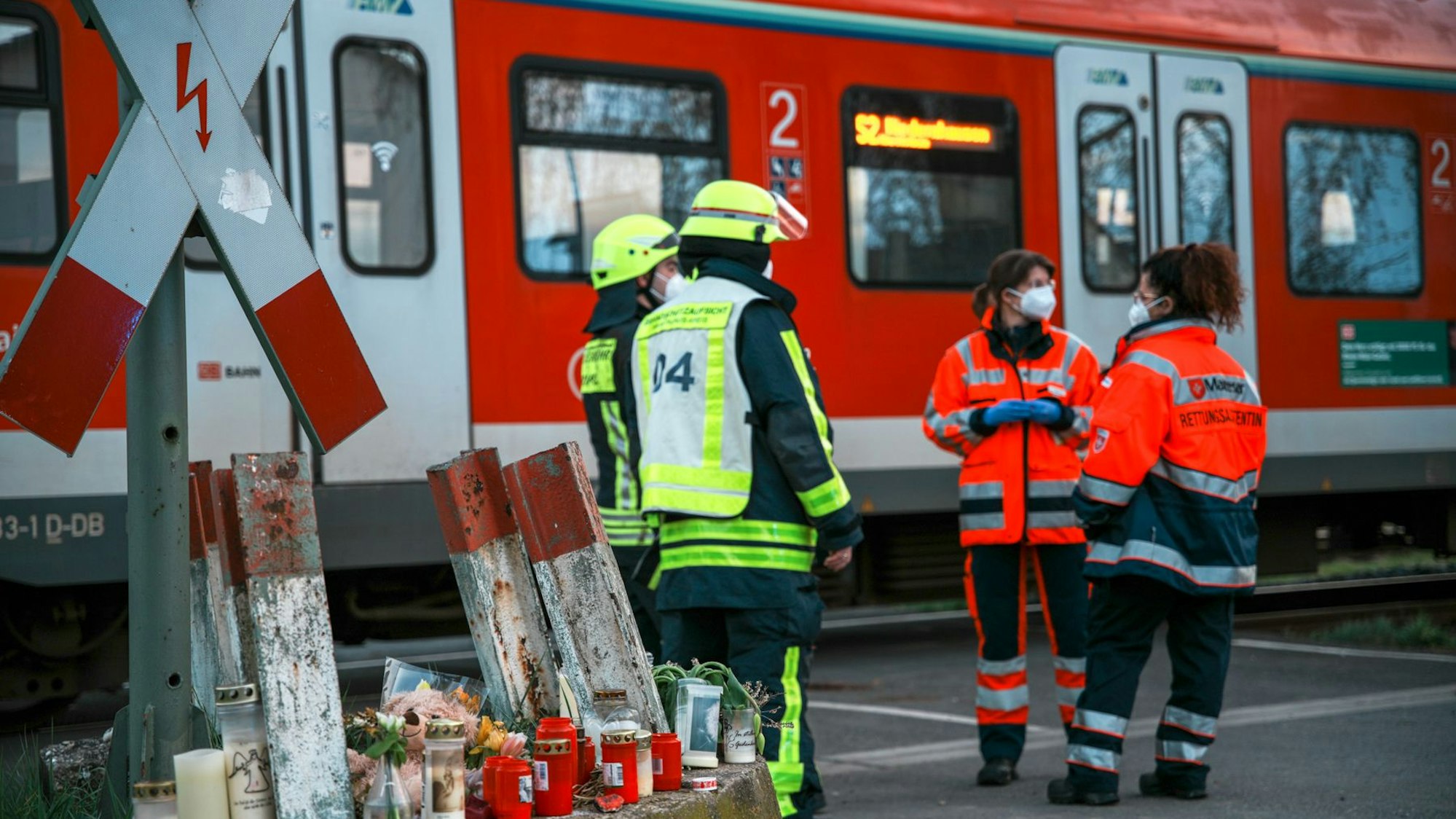 Feuerwehrleute und Sanitäter stehen nach einem Unfall an einem S-Bahnübergang