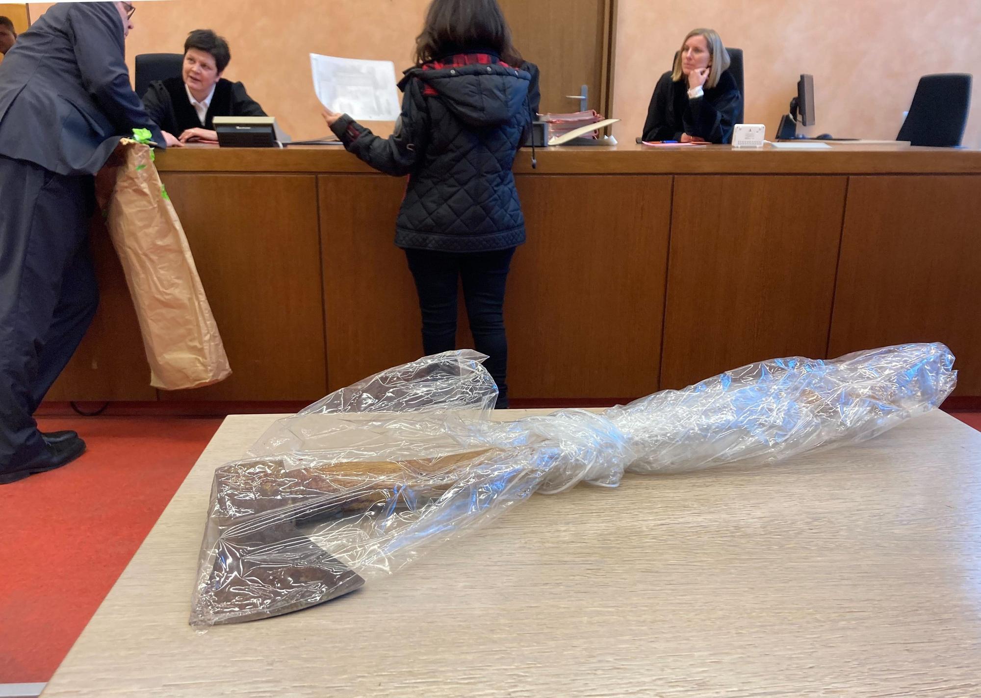 Die Tatwaffe, eine Axt, liegt auf dem Tisch in einem Saal vom Landgericht.