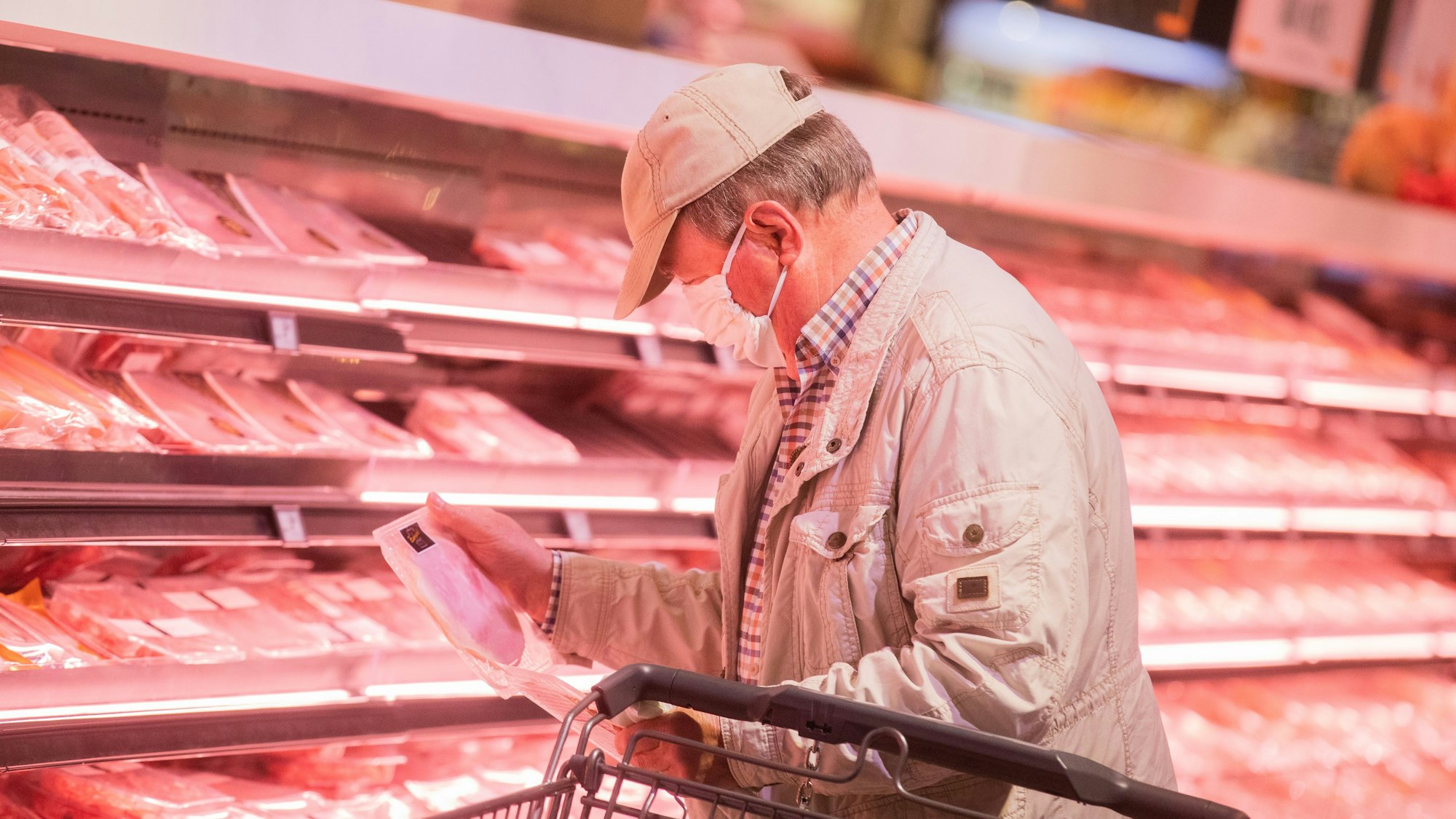 Ein Kunde kauft mit Mund-Nasen-Schutz kauft im Edeka Zurheide ein.