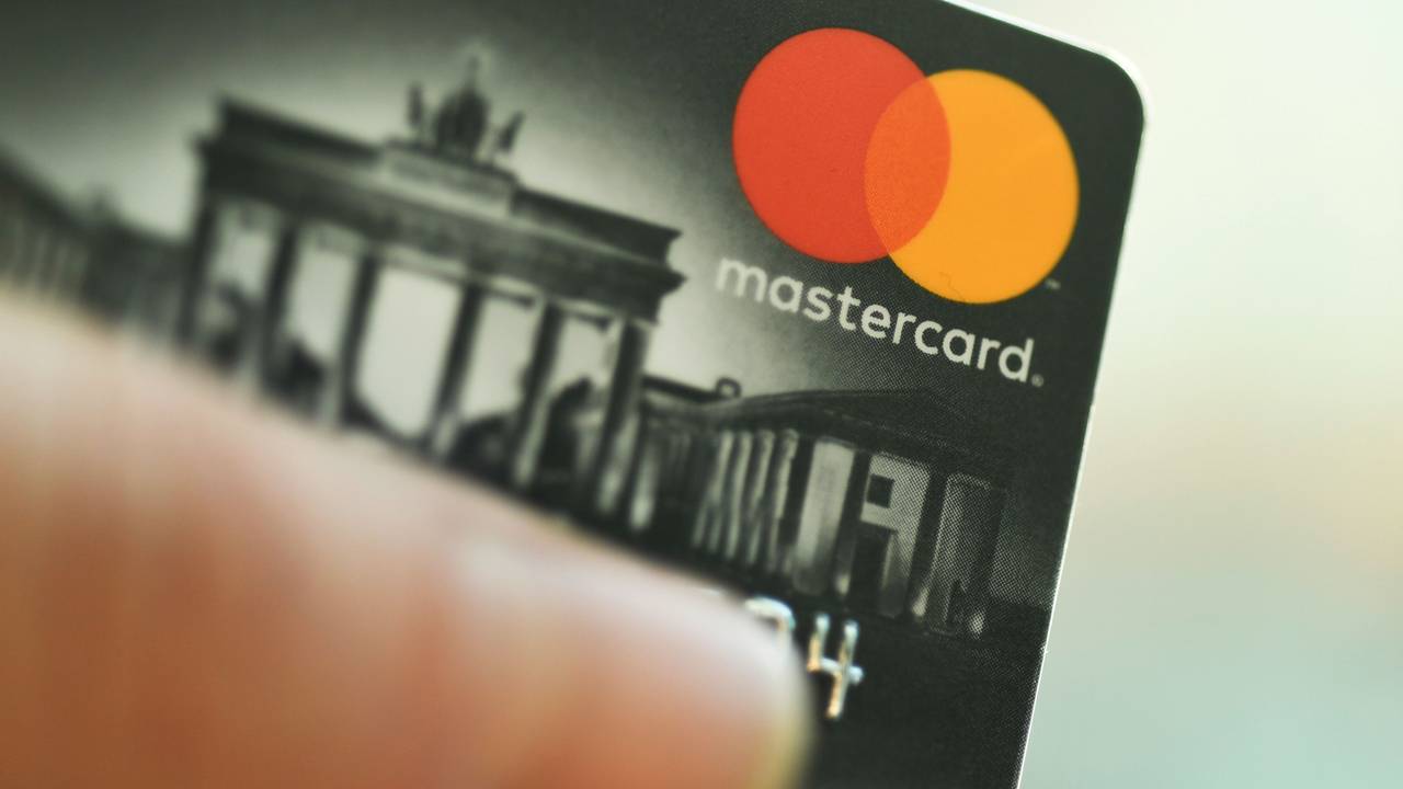 Eine Mastercard-Kreditkarte wird in der Hand gehalten.