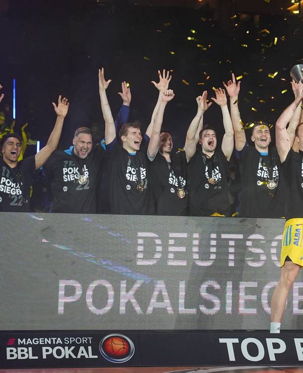 Die Spieler von Alba Berlin jubeln mit dem BBL-Pokal.