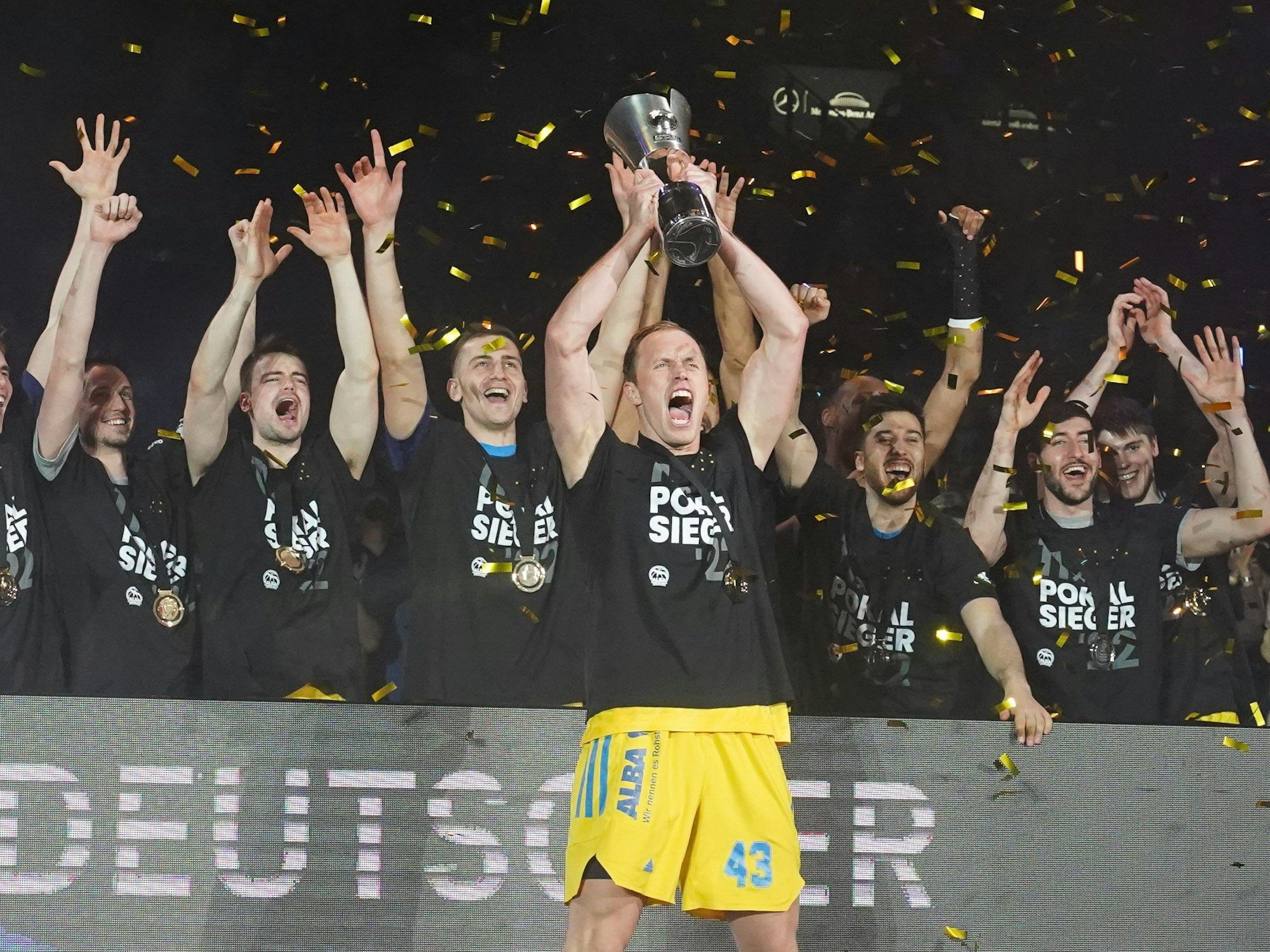Die Spieler von Alba Berlin jubeln mit dem BBL-Pokal.