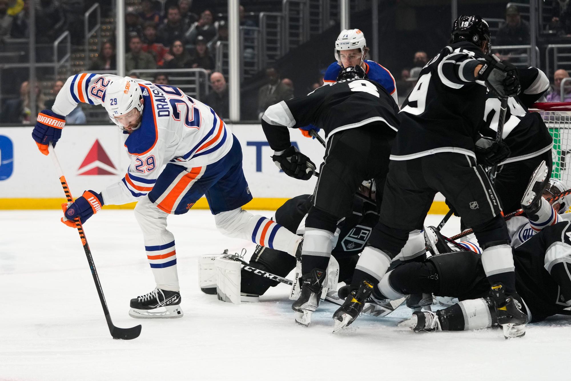 Leon Draisaitl (29) von den Edmonton Oilers bewegt den Puck, während sich die Spieler der Los Angeles Kings um das Netz herum verheddern.
