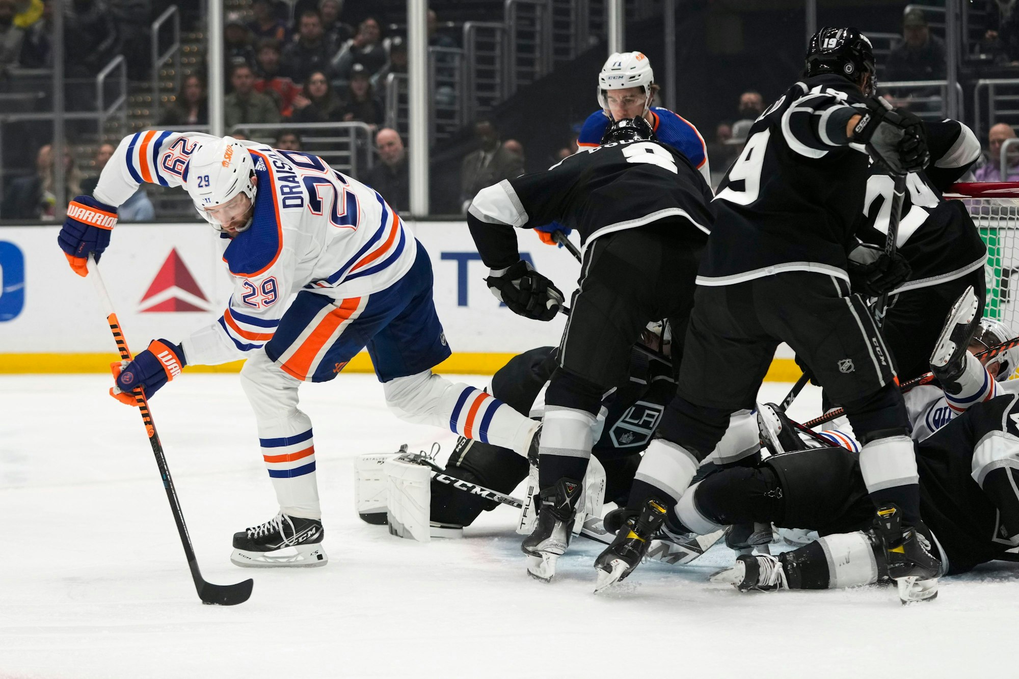 Leon Draisaitl (29) von den Edmonton Oilers bewegt den Puck, während sich die Spieler der Los Angeles Kings um das Netz herum verheddern.