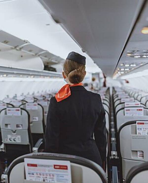 Eine Stewardess in einer Passagierkabine.