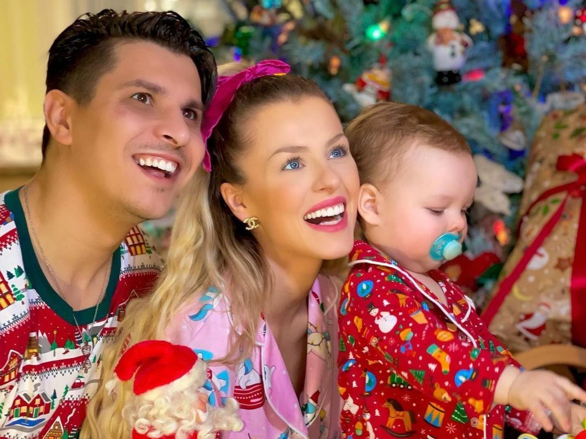 Patricija Ionel und Alexandru Ionel freuen sich mit ihrem Sohn vor dem Weihnachtsbaum.