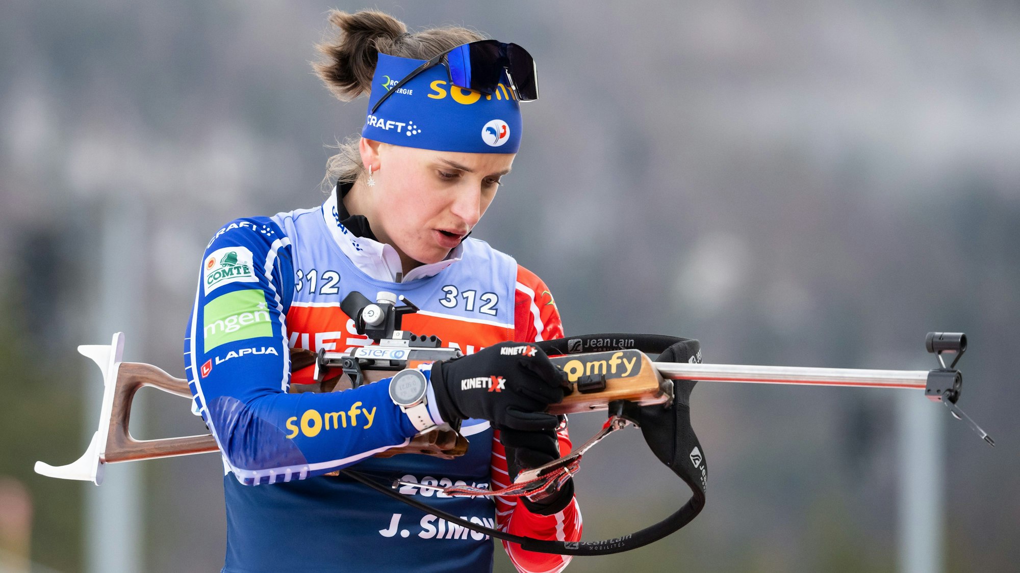 Biathletin Julia Simon aus Frankreich in Aktion mit ihrem Gewehr.