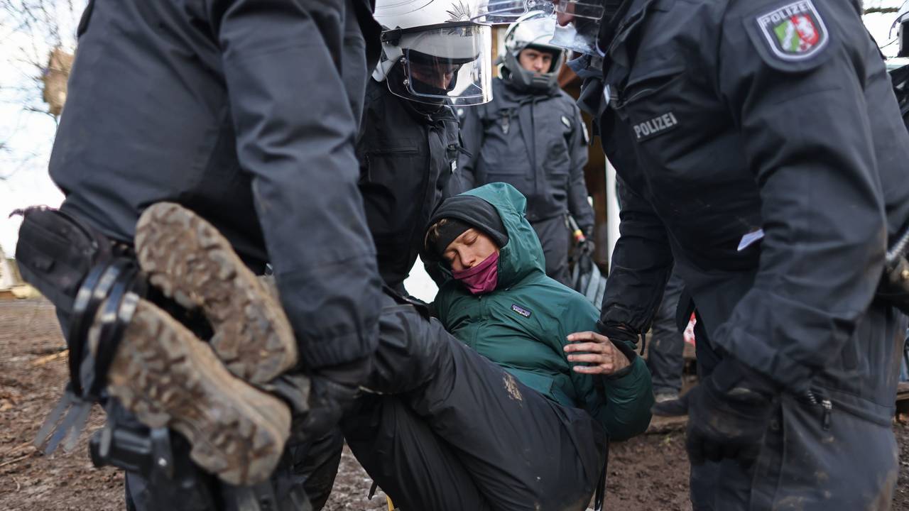 Polizisten tragen bei der Räumung von Lützerath eine Demonstrantin fort.