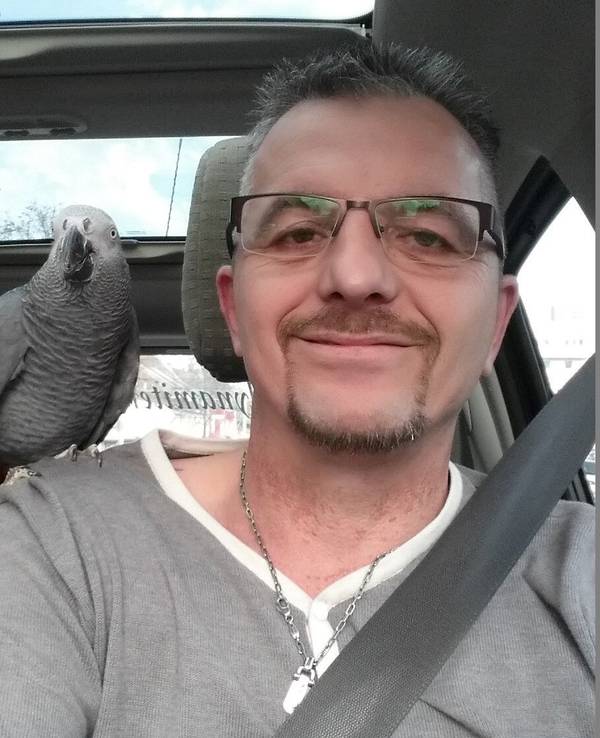 Ingo Stromberg mit Papagei Freddy: Der Vogel sitzt auf der Schulter.