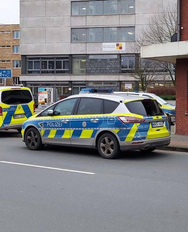 Polizei-Autos stehen vor einer Schule.