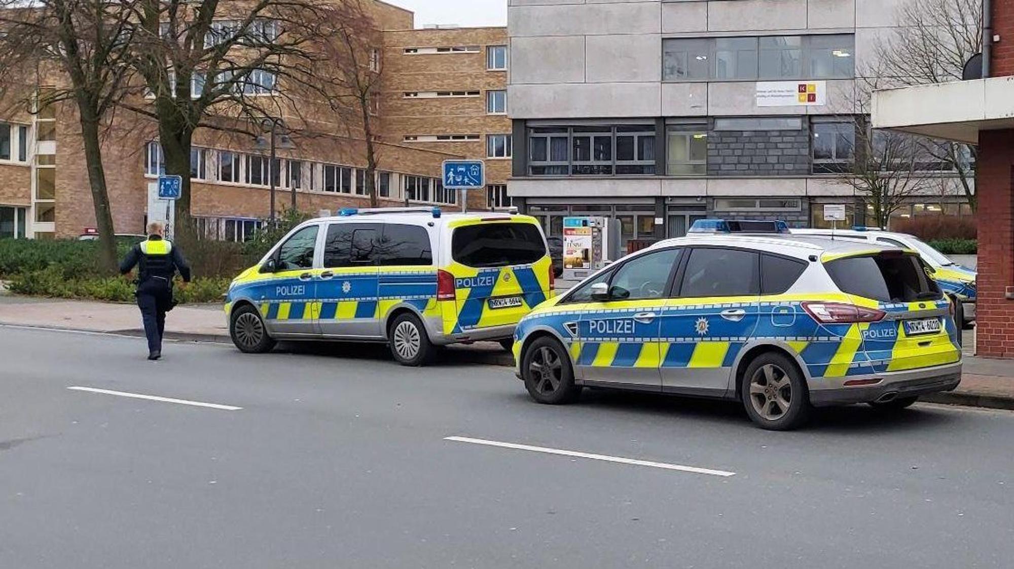 Polizei-Autos stehen vor einer Schule.