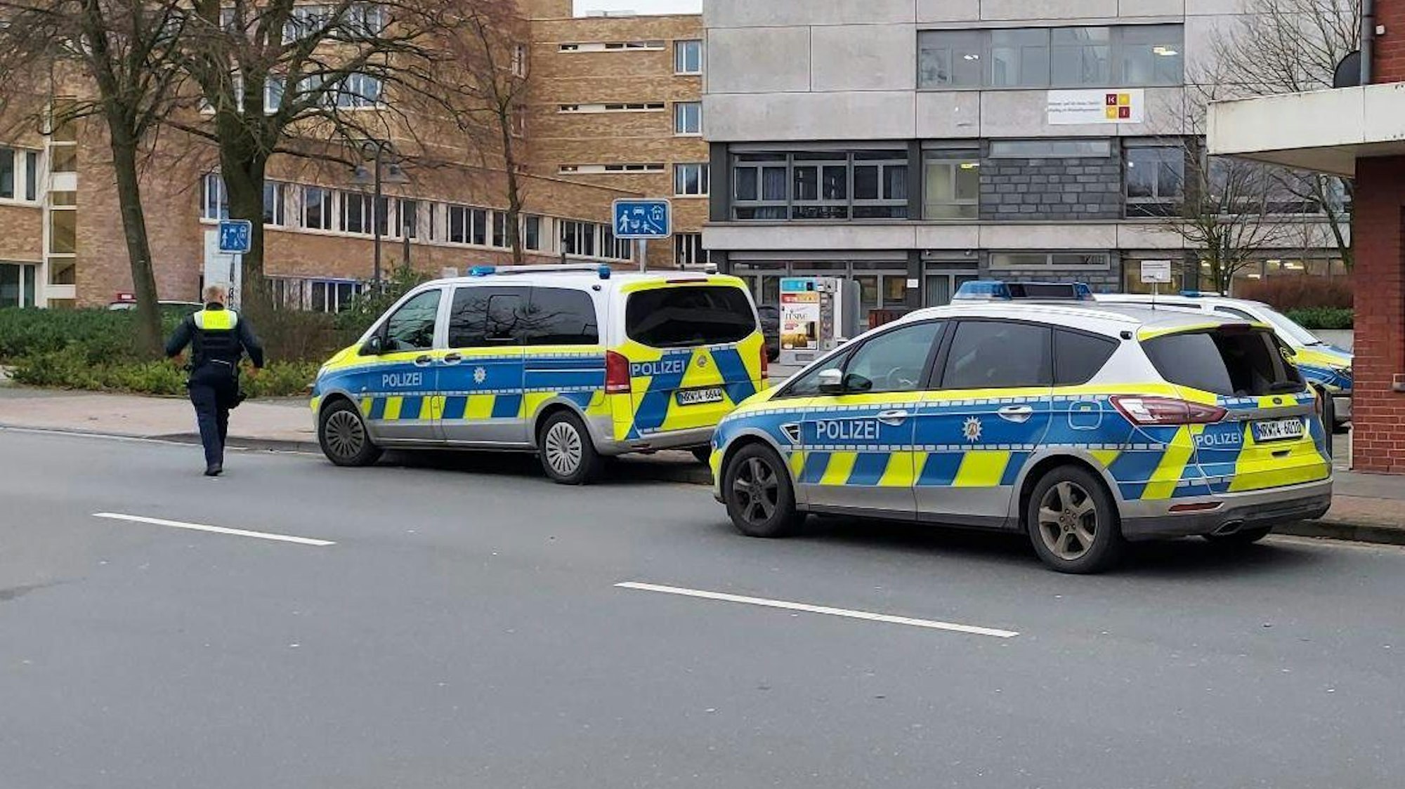 Polizei-Autos stehen vor einer Schule.