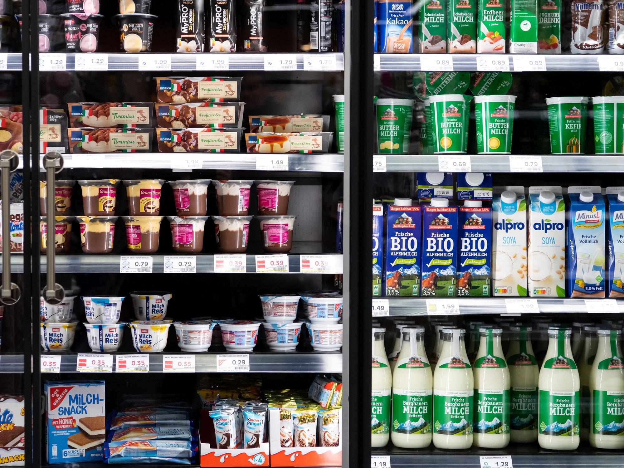 Milchprodukte von verschiedenen Herstellern stehen in einem Supermarktregal.