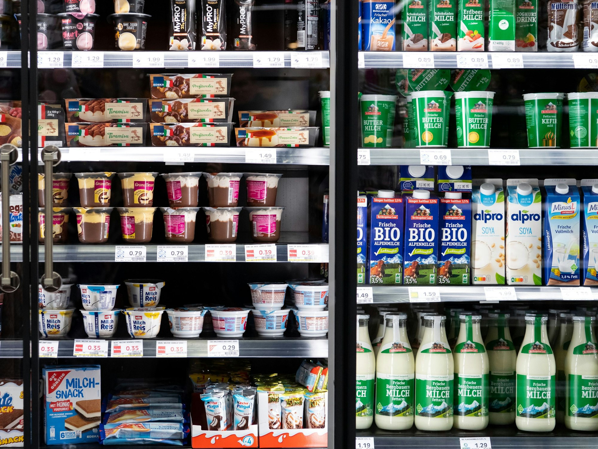 Milchprodukte von verschiedenen Herstellern stehen in einem Supermarktregal.