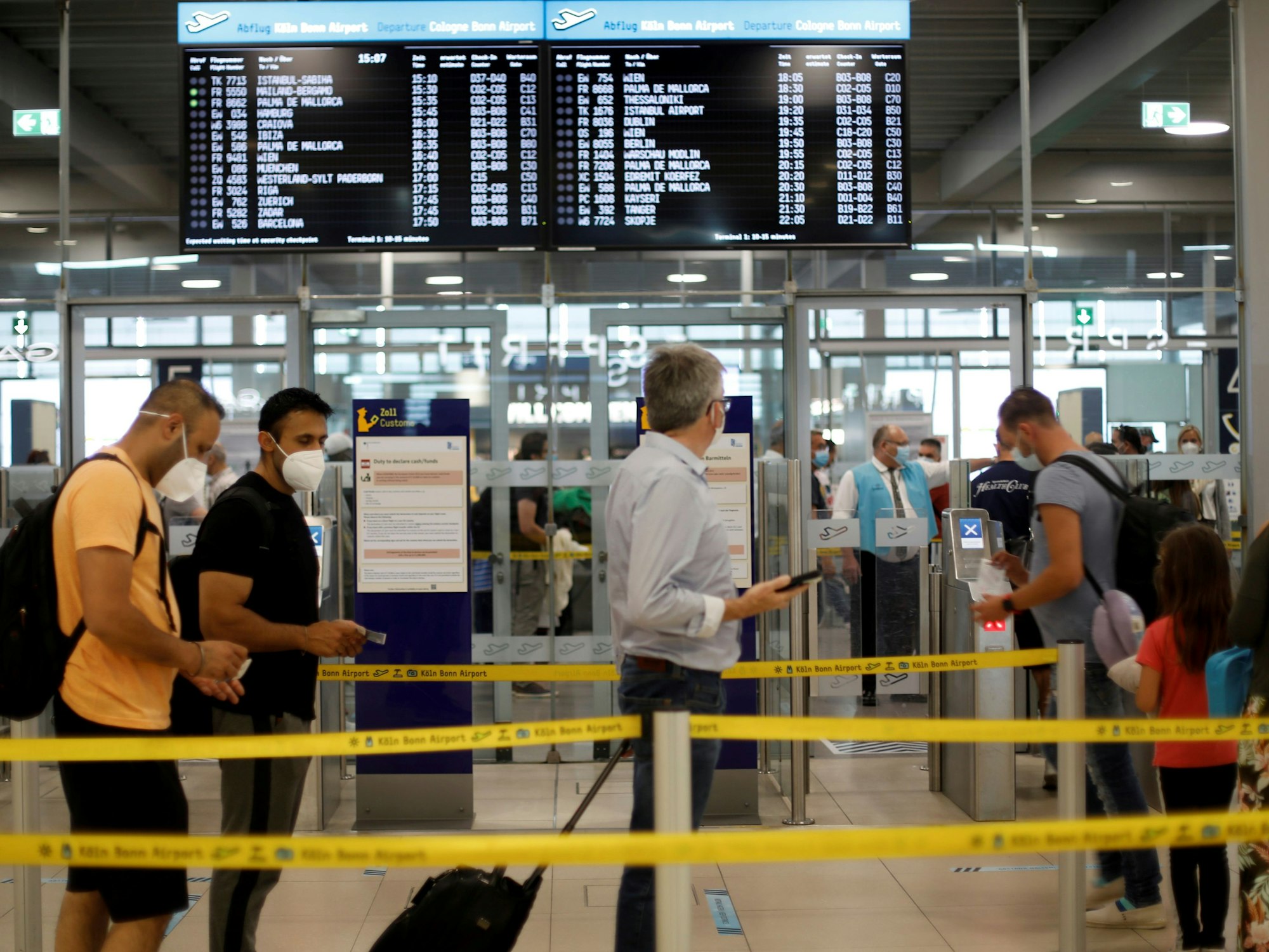 Menschen stehen Schlange vor einem Abflug am Flughafen Köln/Bonn.