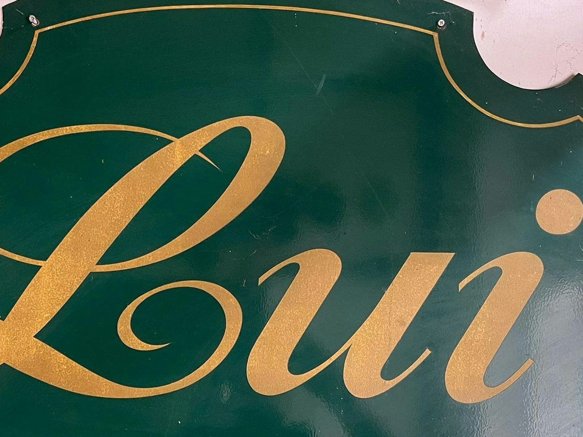 Auf einem Schild steht in verschnörkelter Schrift Lui.