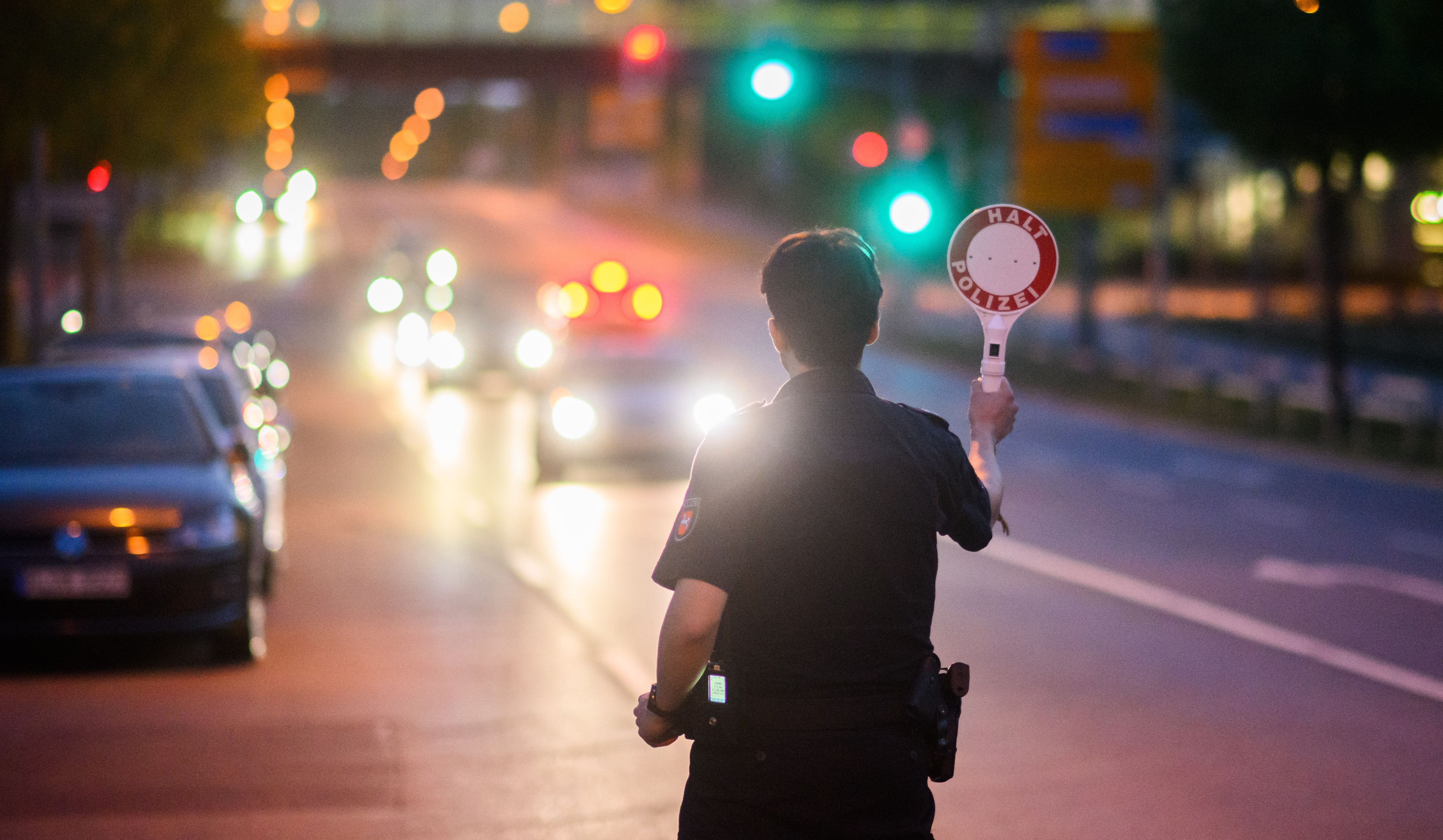 Ein Polizist stoppt ein Fahrzeug bei einer Kontrolle am Expo-Park.