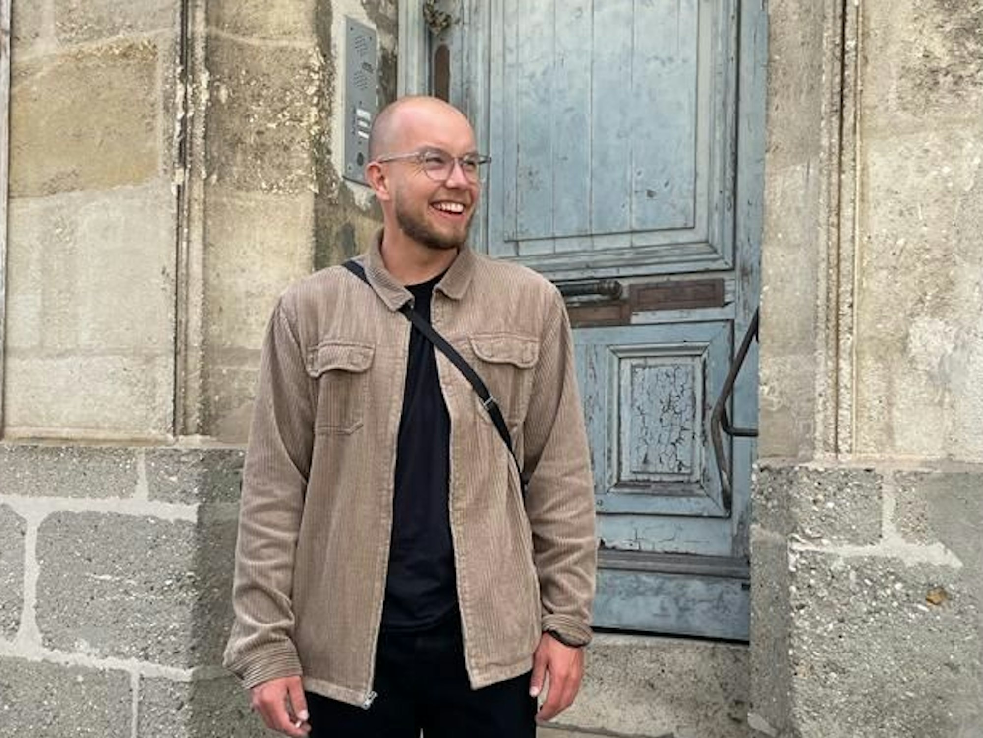 YouTuber Patrick Temp steht lächelnd vor einer Wand.