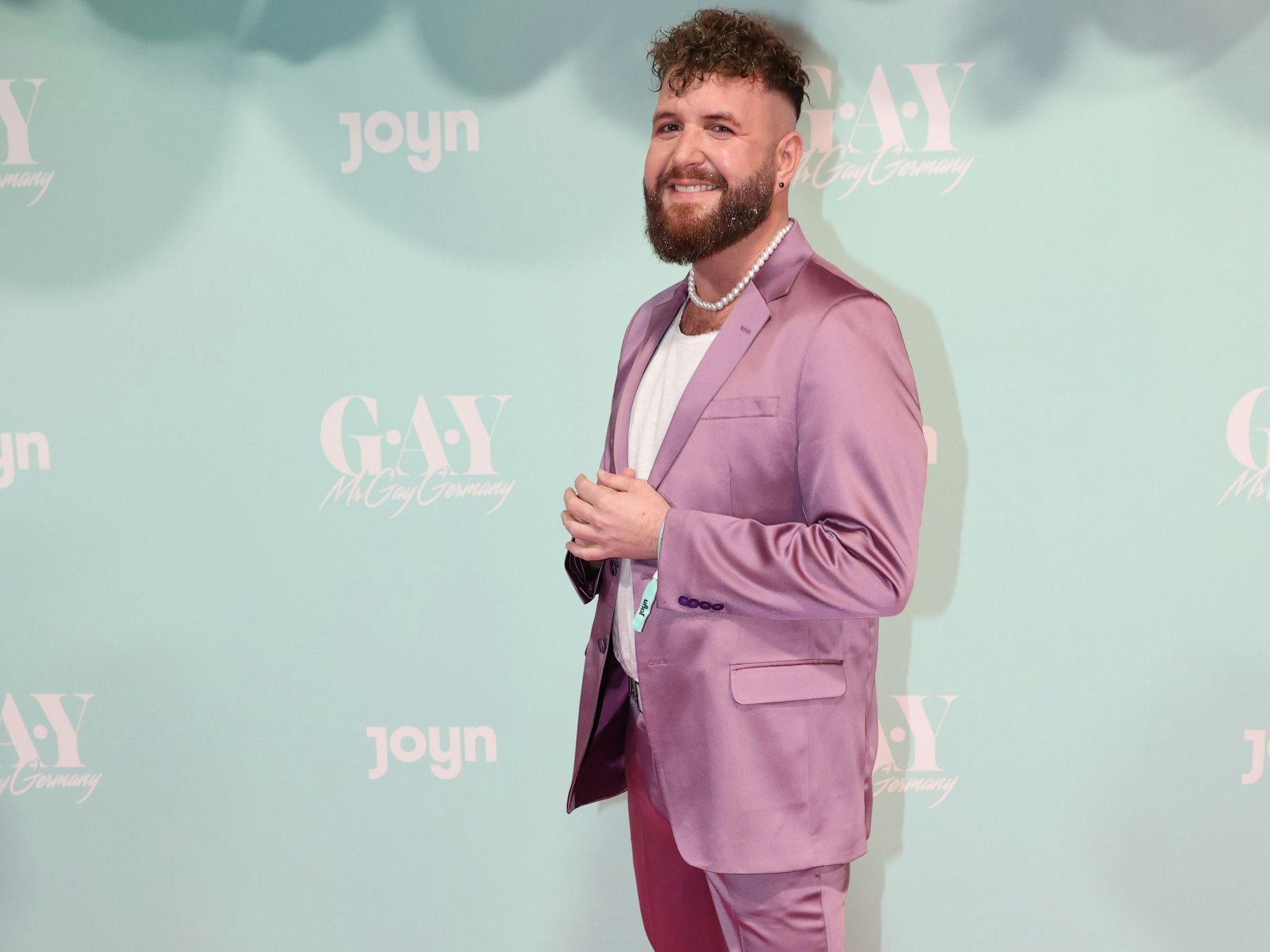 Mr-Gay-Germany-Kandidat Giu lächelt in die Kamera.