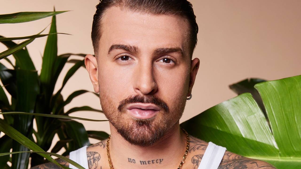 Gigi Birofio posiert hinter mehreren Pflanzen.