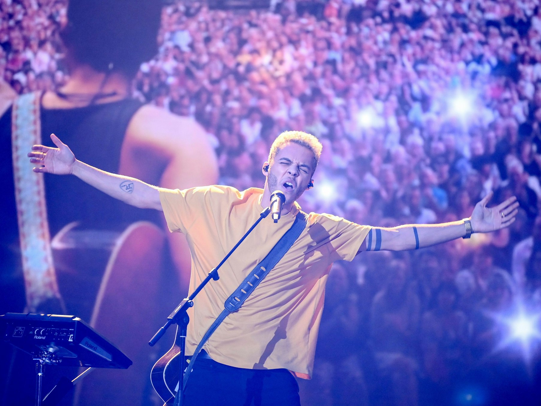 Malik Harris steht beim deutschen ESC-Vorentscheid auf der Bühne und singt in sein Mikrofon.