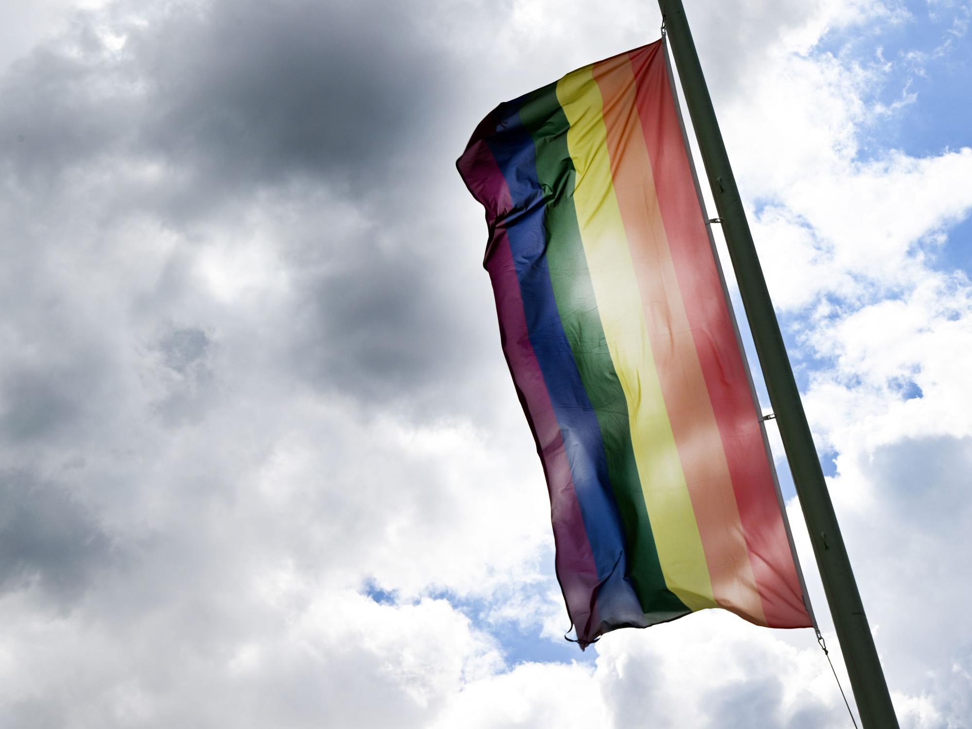 Eine Regenbogenflagge weht im Wind.