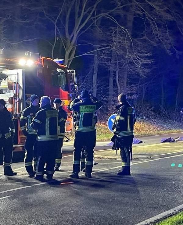 Einsatzkräfte stehen auf der Straße nahe der Querungshilfe, wo eine Frau von einem Auto erfasst worden war.