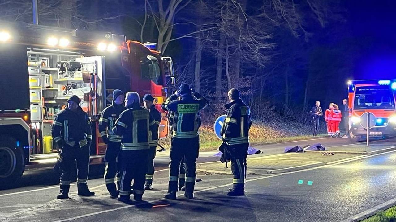 Einsatzkräfte stehen auf der Straße nahe der Querungshilfe, wo eine Frau von einem Auto erfasst worden war.