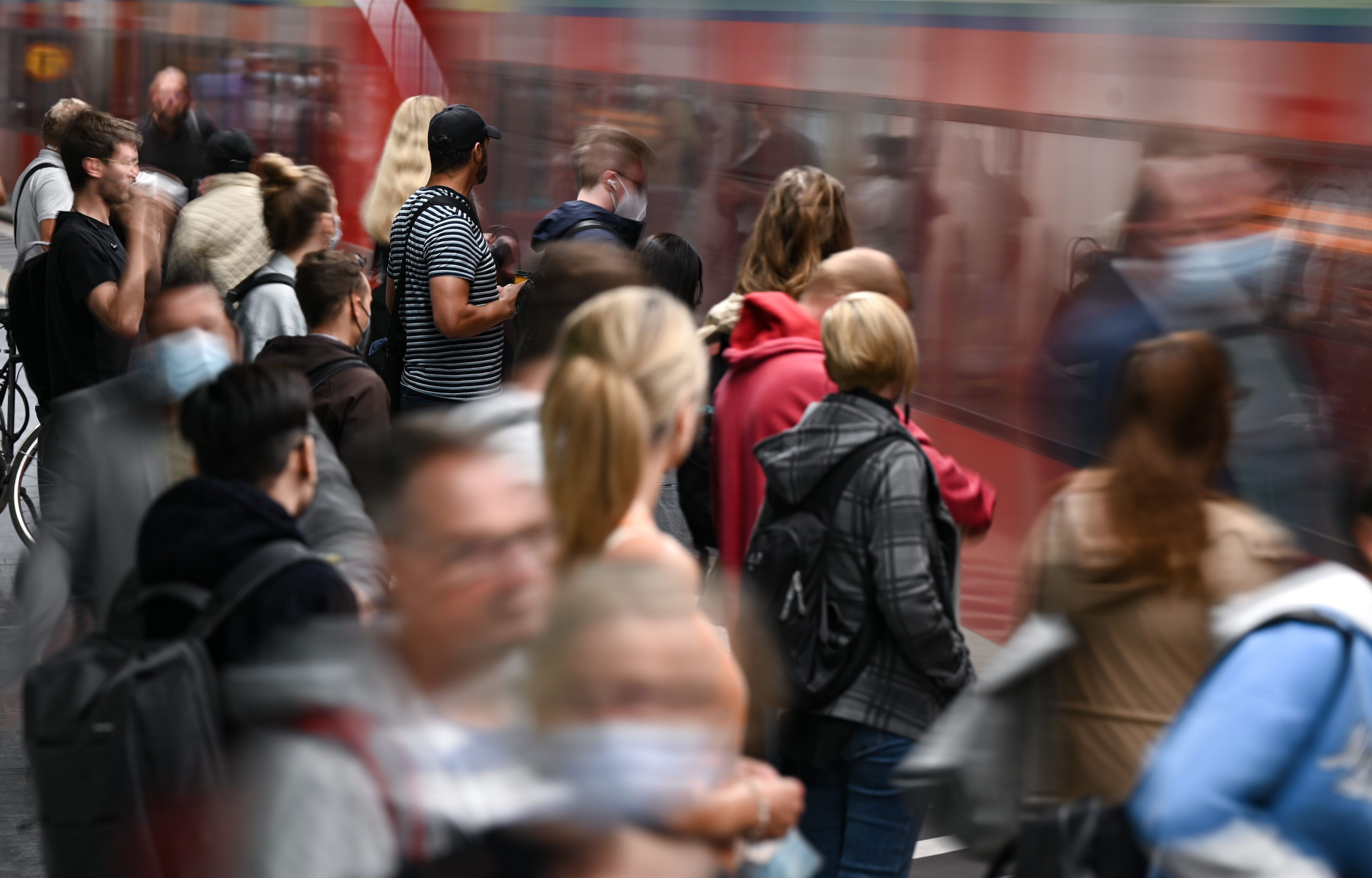 Fahrgäste warten an einem Gleis im Tiefbahnhof des Frankfurter Hauptbahnhofs, während eine S-Bahn einfährt.