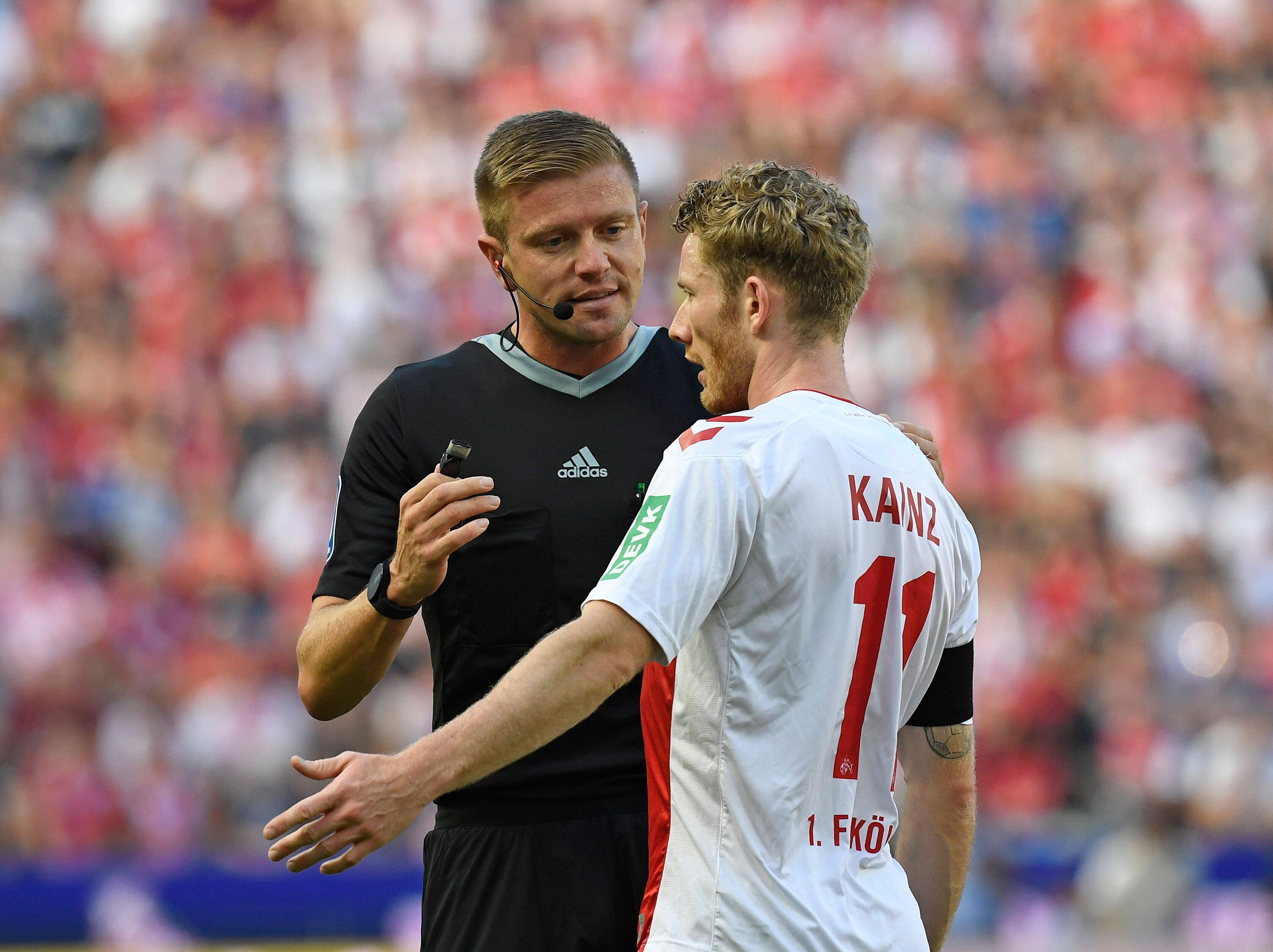 Schiedsrichter Robert Schröder und FC-Profi Florian Kainz am 7. August 2022 beim Saison-Auftakt gegen Schalke 04 im Gespräch.