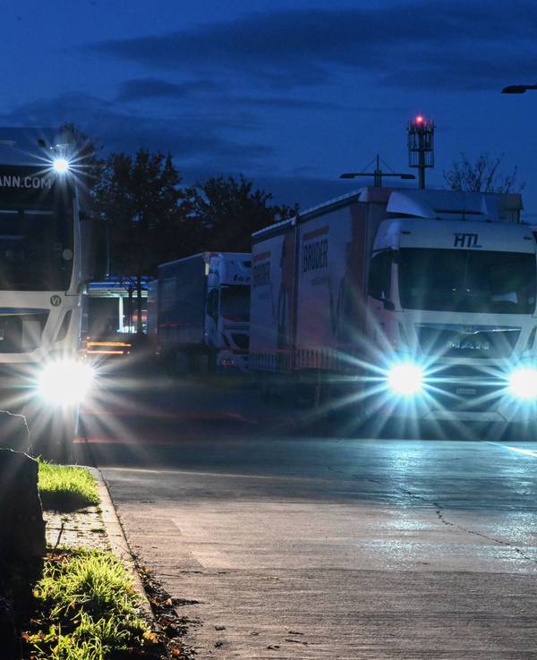 Lastwagen stehen in der Dunkelheit auf einem Rastplatz bei Stuttgart.