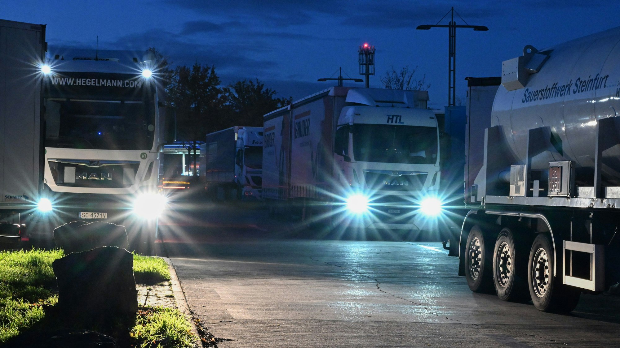 Lastwagen stehen in der Dunkelheit auf einem Rastplatz bei Stuttgart.