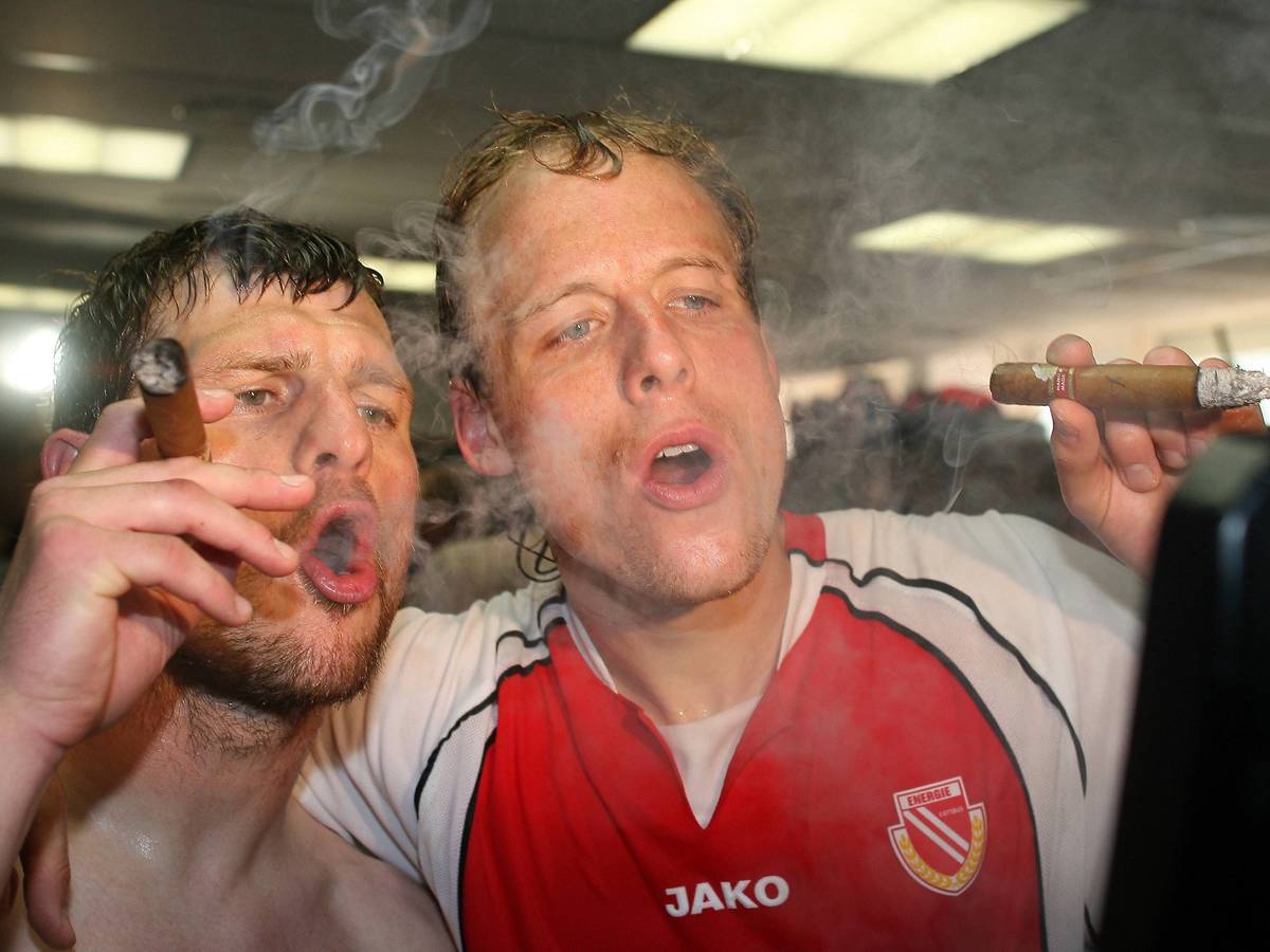 Kevin McKenna (rechts) und Steffen Baumgart (beide Cottbus) gönnen sich während der Aufstiegsfeier 2006 eine Zigarre