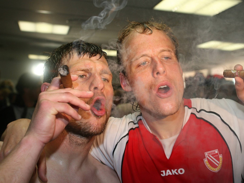 Kevin McKenna (rechts) und Steffen Baumgart (beide Cottbus) gönnen sich während der Aufstiegsfeier 2006 eine Zigarre