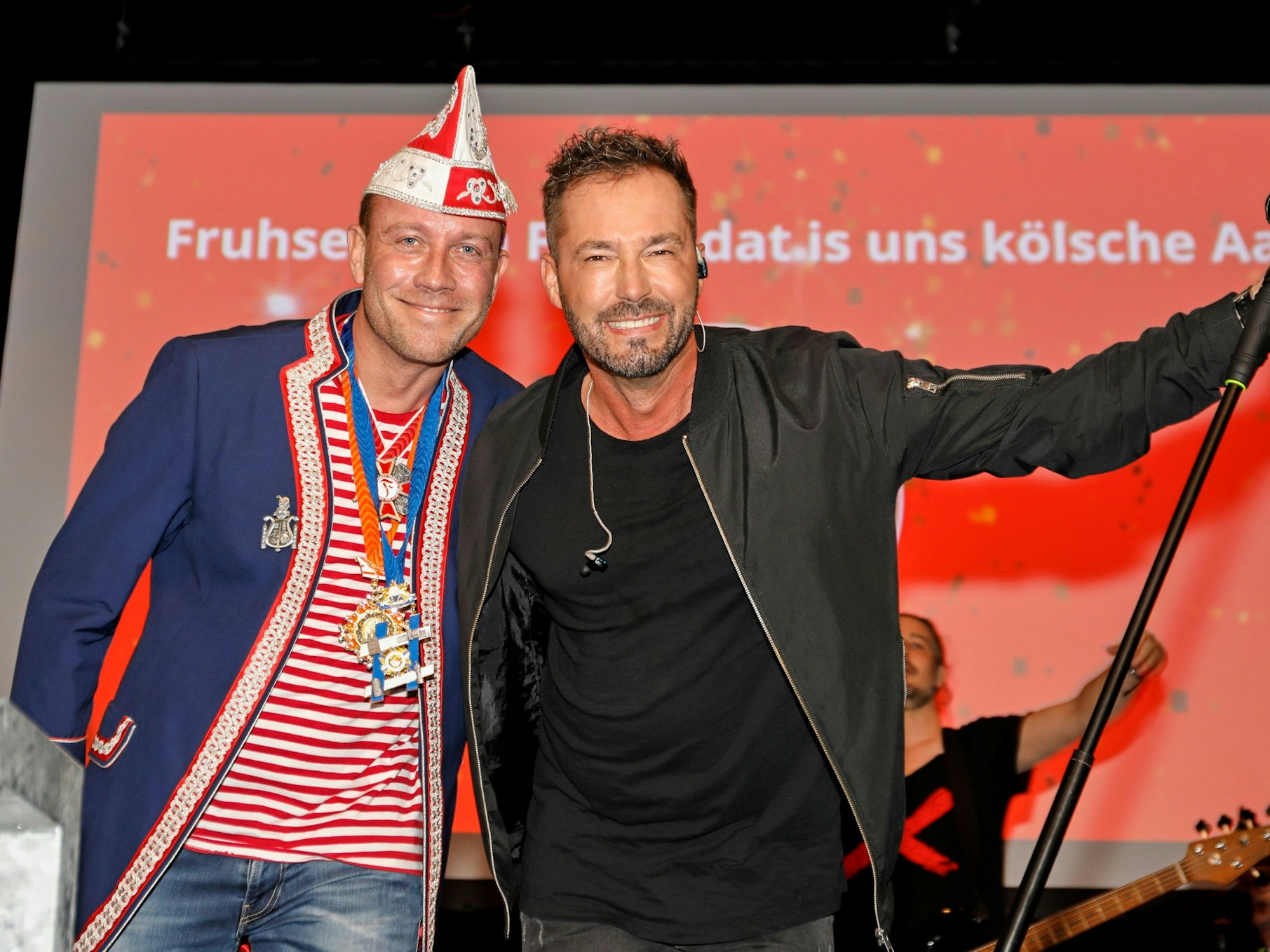 Zwei Männer stehen auf einer Bühne.