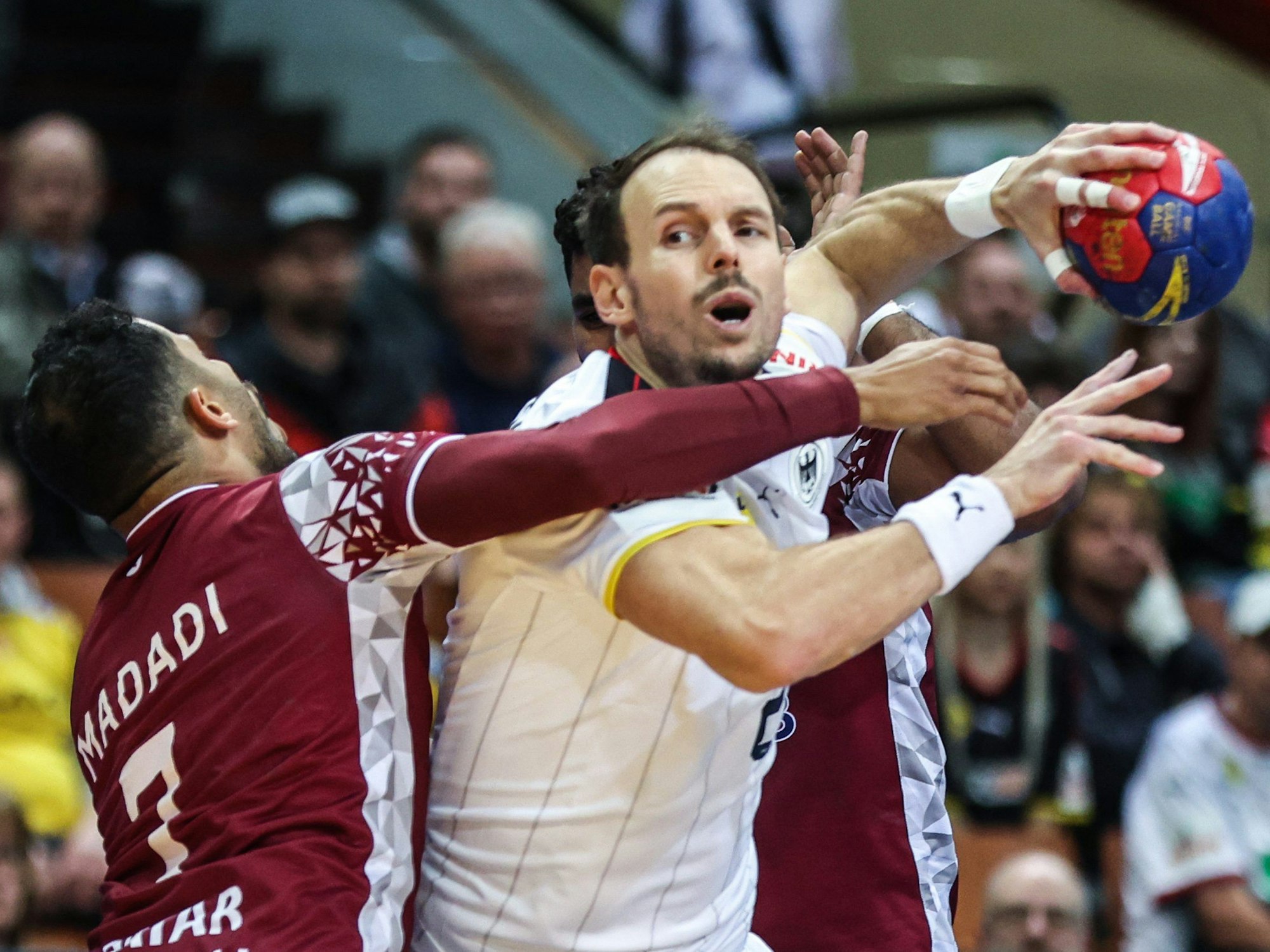 Katars Ahmad Madadi (l) und Abdelrahman Tarek Abdalla in Aktion gegen Deutschlands Kai Häfner (M).