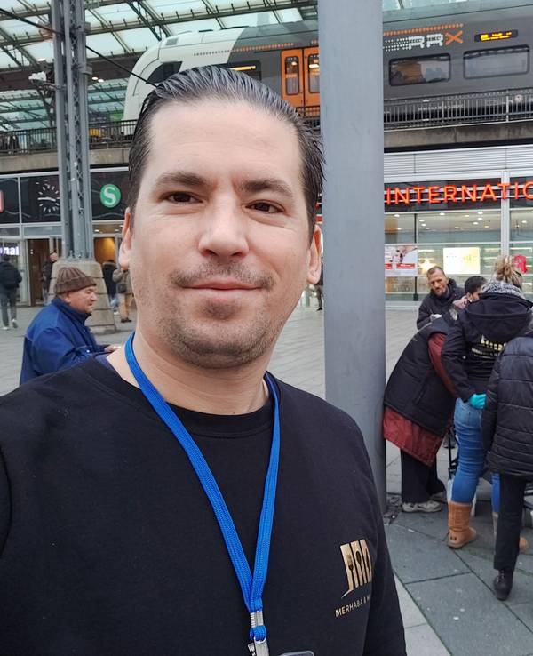 Ein Mann steht vor einer Gruppe und macht ein Selfie.