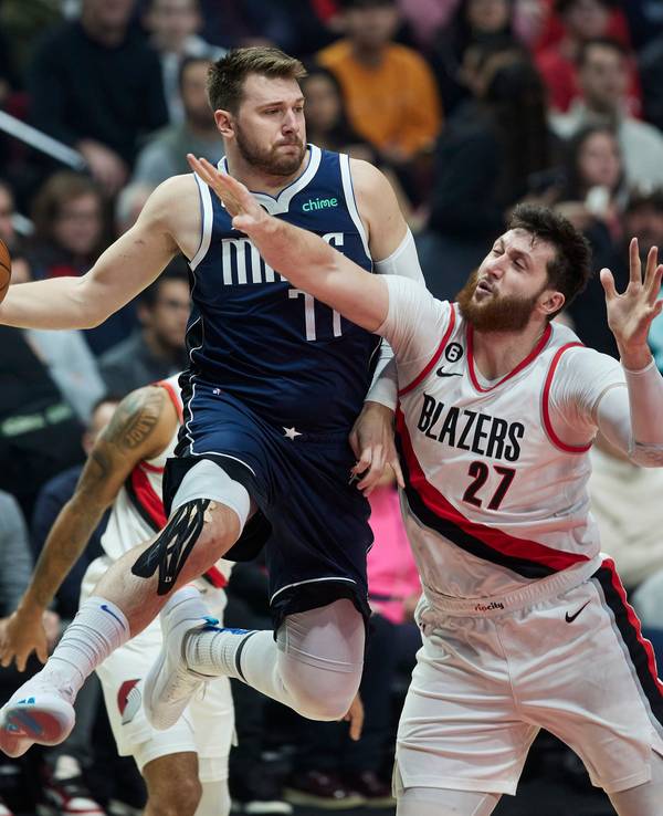 Dallas Mavericks Guard Luka Doncic (l) wirft den Ball vor Portland Trail Blazers Center Jusuf Nurkic.