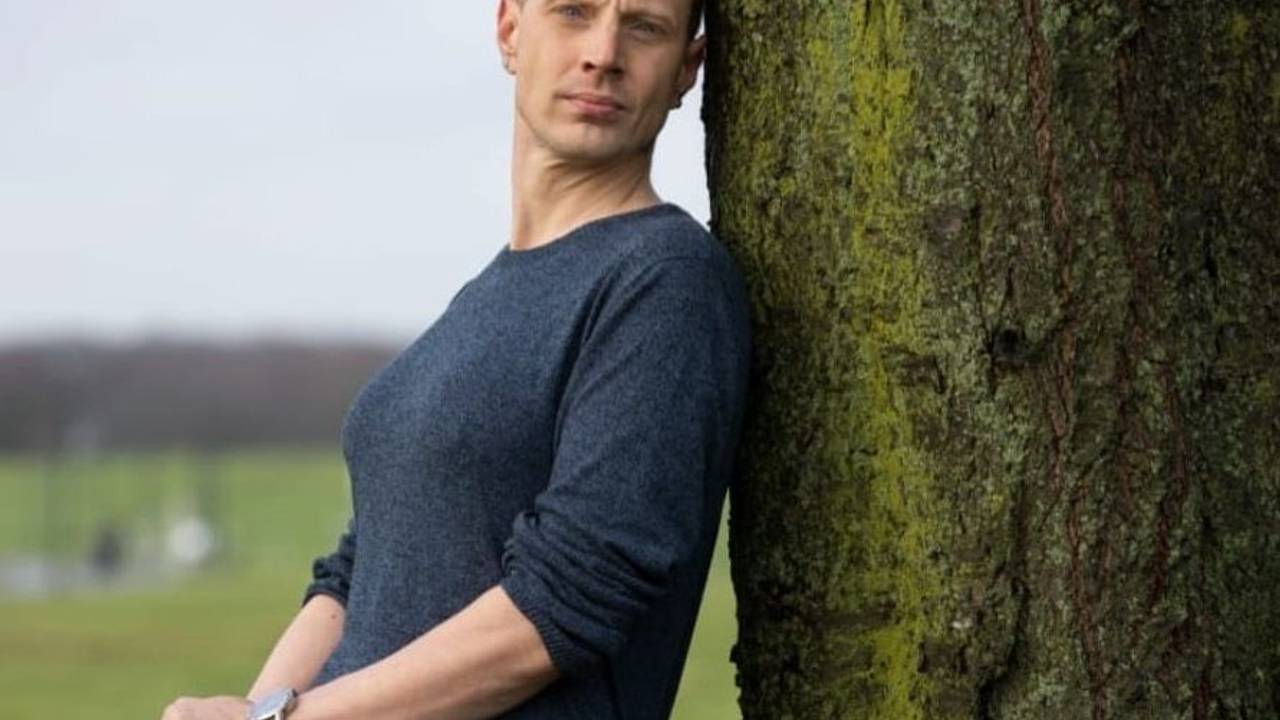 Marc Dominik Rosenzweig wollte eine Frau sein. Hier lehnt er als Mann, aber mit Brust, an einem Baum.