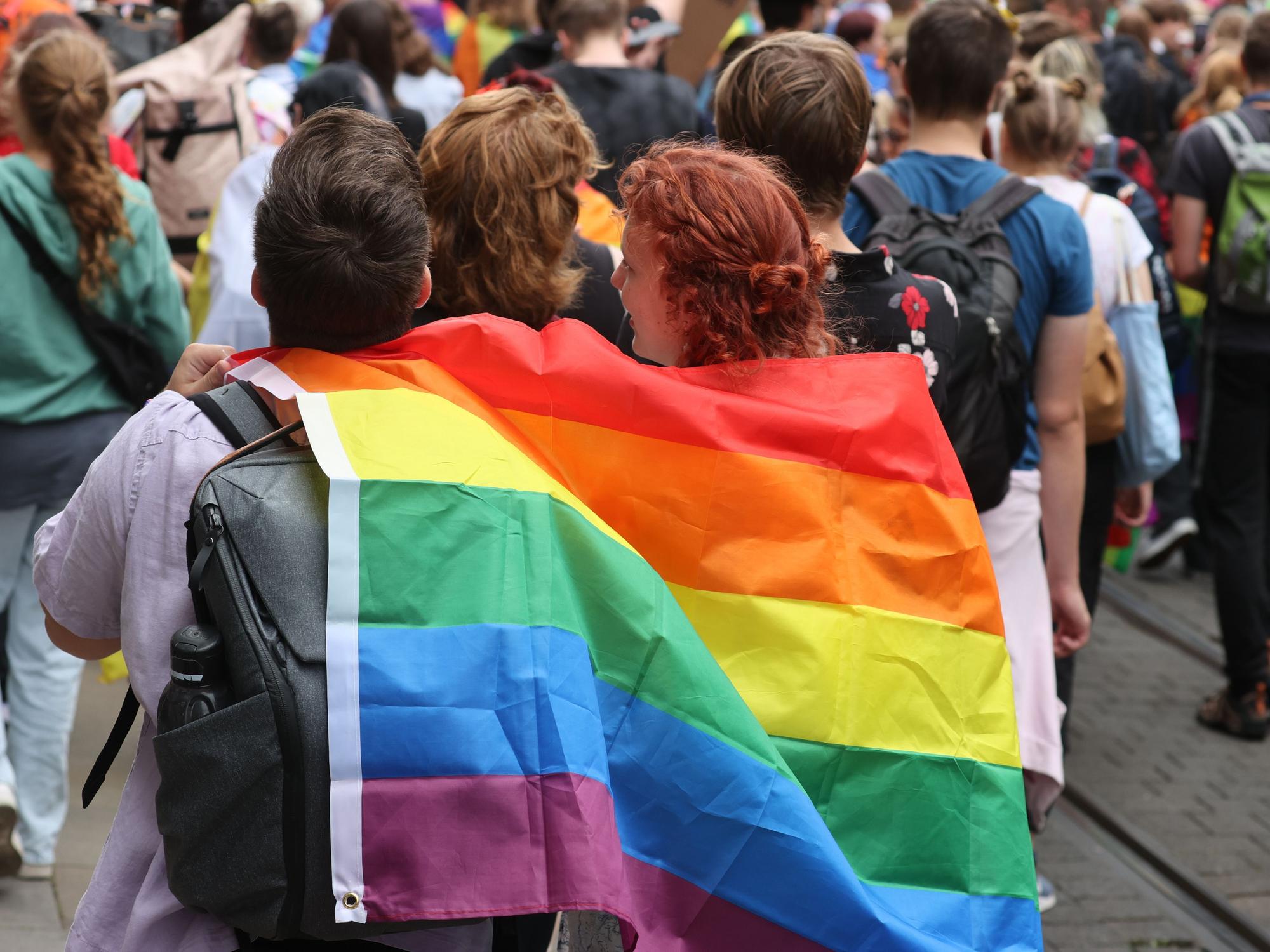 Menschen mit Regenbogenfahne beim CSD in Erfurt.